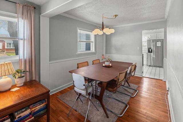 dining space featuring a notable chandelier, wainscoting, and a wealth of natural light