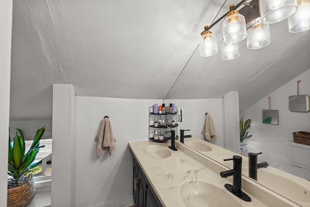bathroom featuring a sink, double vanity, and a textured ceiling