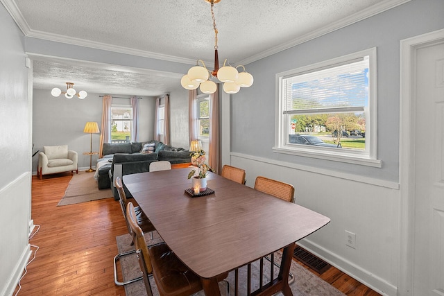 dining area featuring visible vents, light wood-style flooring, and a notable chandelier