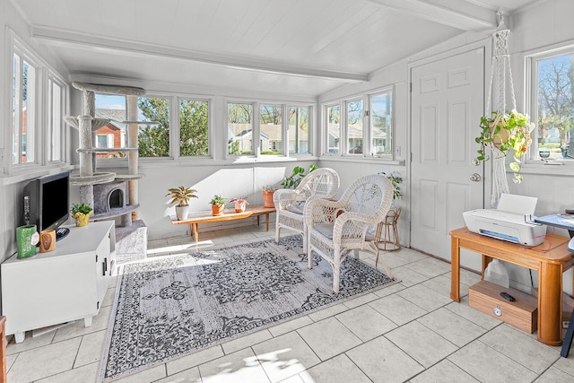 sunroom / solarium featuring beam ceiling and a healthy amount of sunlight