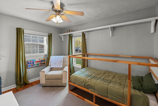 bedroom with wood finished floors, baseboards, and a ceiling fan