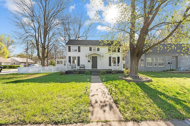 view of front of house with a front yard and fence