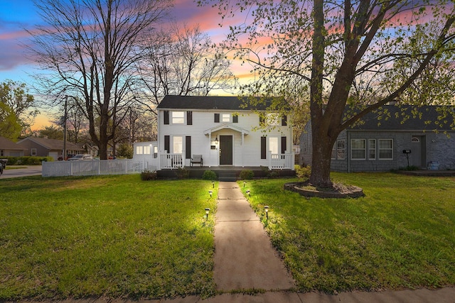 view of front facade featuring a front yard and fence