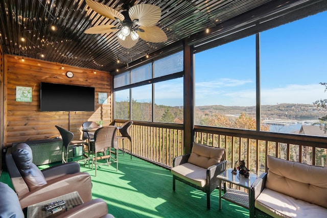 sunroom with floor to ceiling windows, carpet flooring, outdoor lounge area, and ceiling fan