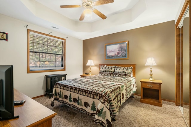 bedroom with baseboards, a raised ceiling, visible vents, ceiling fan, and carpet