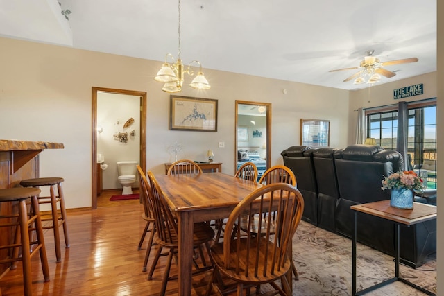 dining space with light wood-type flooring and ceiling fan with notable chandelier