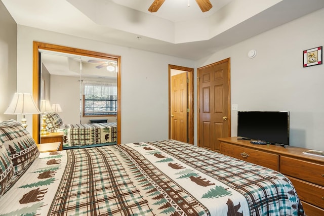 bedroom with a tray ceiling, a closet, and a ceiling fan