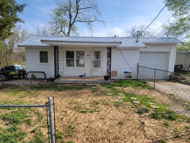 350 Kentling Ave, Highlandville, MO 65669 - single story home with metal roof, fence, an attached garage, and covered porch