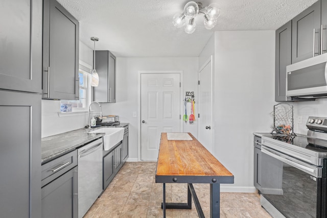 715 Woodlawn St, Marshfield, MO 65706 - kitchen featuring stone counters, gray cabinets, a textured ceiling, stainless steel appliances, and a sink