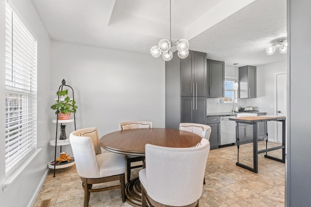 715 Woodlawn St, Marshfield, MO 65706 - dining area with visible vents, baseboards, a raised ceiling, a chandelier, and a textured ceiling
