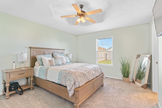 715 Woodlawn St, Marshfield, MO 65706 - bedroom with baseboards, a textured ceiling, a ceiling fan, a tray ceiling, and light colored carpet