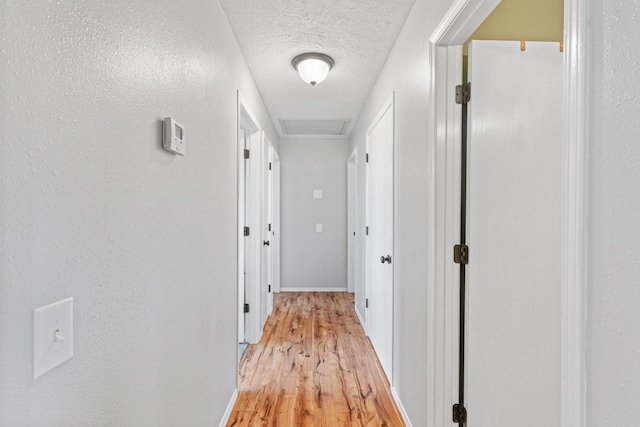 715 Woodlawn St, Marshfield, MO 65706 - hallway featuring baseboards, a textured wall, light wood-style flooring, a textured ceiling, and visible vents