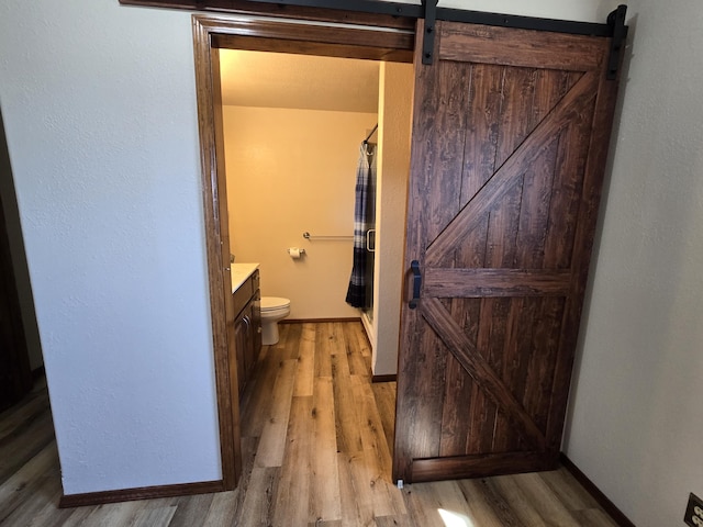 21282 County Road 295, Hermitage, MO 65668 - full bathroom with toilet, baseboards, wood finished floors, a shower stall, and vanity