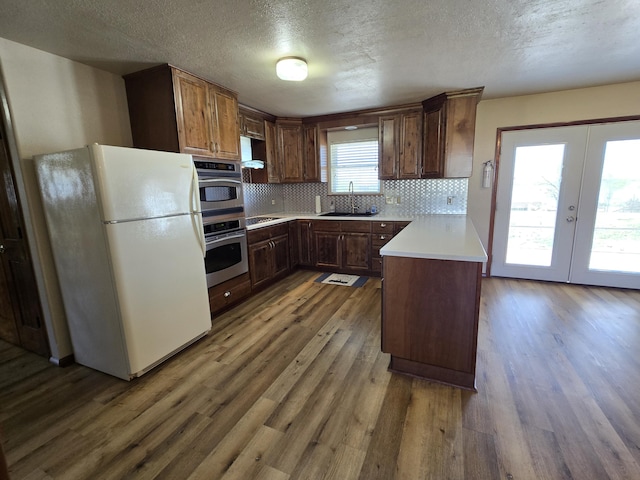21282 County Road 295, Hermitage, MO 65668 - kitchen featuring wood finished floors, a sink, french doors, backsplash, and freestanding refrigerator