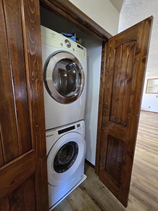 21282 County Road 295, Hermitage, MO 65668 - laundry area featuring stacked washer / drying machine, wood finished floors, and laundry area
