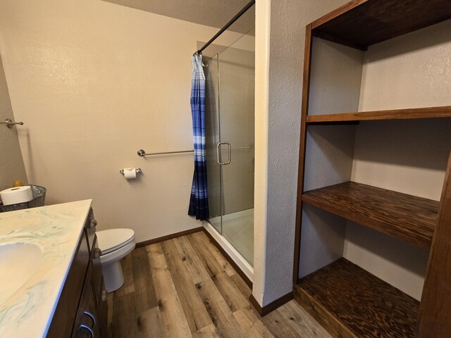 21282 County Road 295, Hermitage, MO 65668 - bathroom with a shower stall, wood finished floors, toilet, vanity, and baseboards