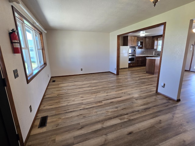 21282 County Road 295, Hermitage, MO 65668 - unfurnished living room with dark wood-type flooring, visible vents, and baseboards