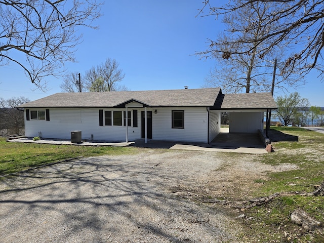 21282 County Road 295, Hermitage, MO 65668 - ranch-style home featuring dirt driveway, roof with shingles, a front lawn, and an attached carport