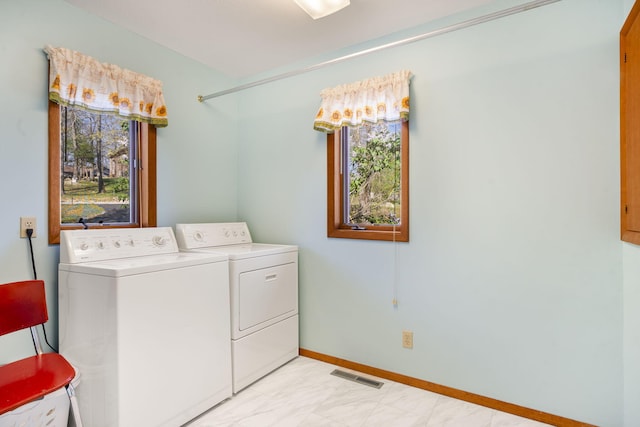 205 Forest Ln, Kimberling City, MO 65686 - laundry area featuring washer and dryer, light marble finish floors, plenty of natural light, and baseboards