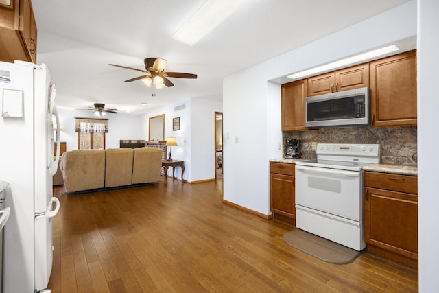 205 Forest Ln, Kimberling City, MO 65686 - kitchen with white appliances, dark wood finished floors, backsplash, and brown cabinets