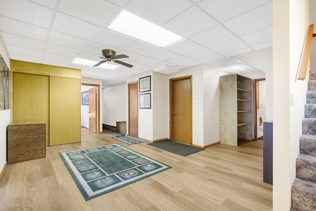 205 Forest Ln, Kimberling City, MO 65686 - basement with light wood-type flooring, a ceiling fan, baseboards, a drop ceiling, and stairway