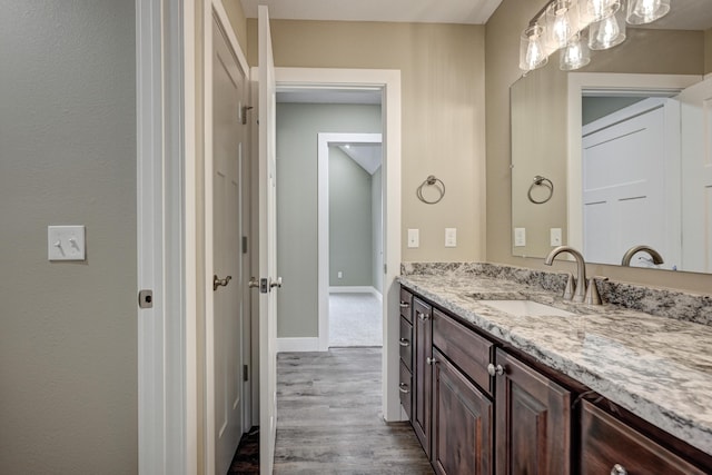 bathroom featuring baseboards, vanity, and wood finished floors