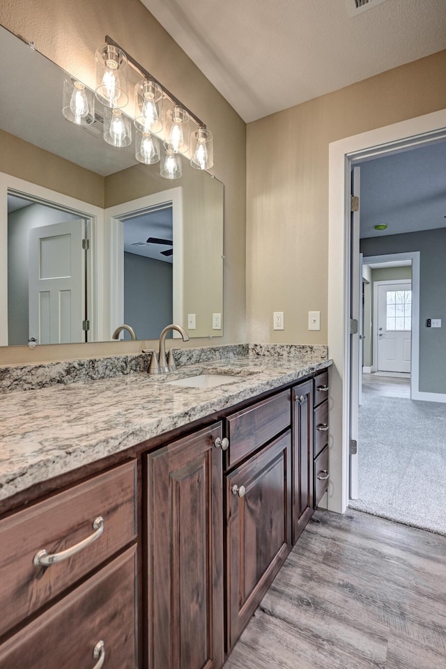 bathroom featuring baseboards, vanity, and wood finished floors