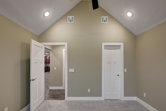 unfurnished bedroom with visible vents, baseboards, high vaulted ceiling, and carpet floors