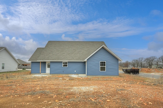 rear view of property with roof with shingles