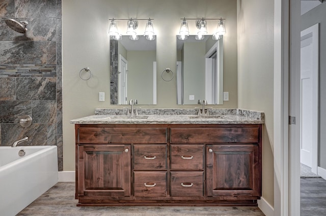 bathroom with wood finished floors, double vanity, a sink, and bathtub / shower combination