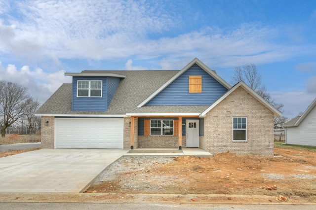 view of front of house with brick siding, a porch, a shingled roof, and driveway