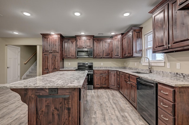 kitchen with a center island, a sink, appliances with stainless steel finishes, light wood-style floors, and recessed lighting