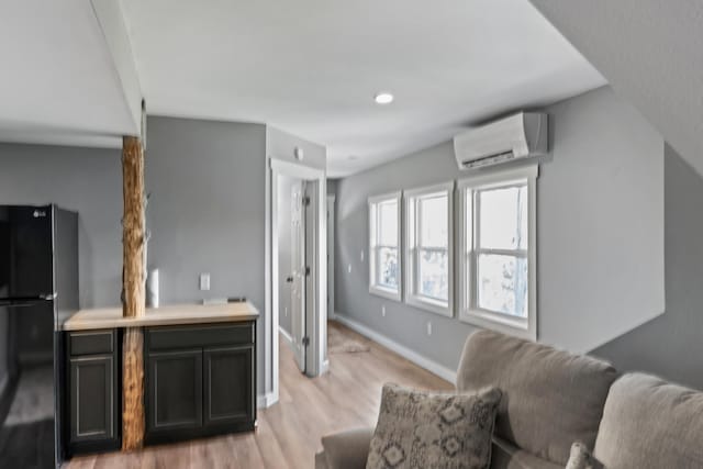 27857 Farm Rd Unit 1250, Golden, MO 65658 - living area featuring a wall unit AC, light wood finished floors, and baseboards