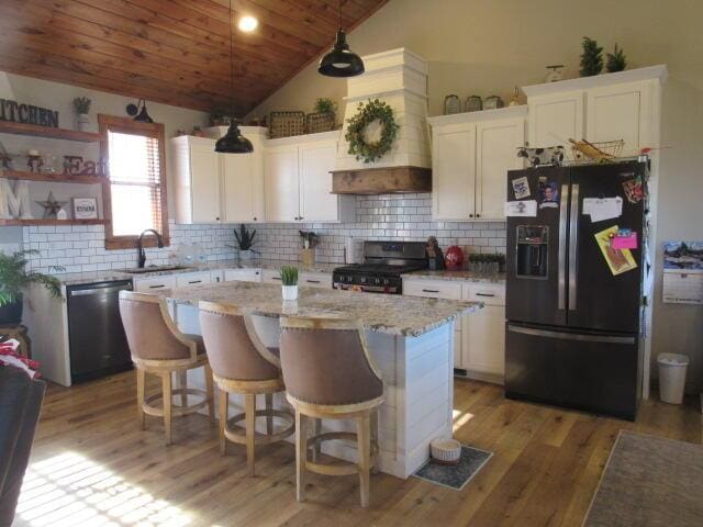 kitchen with gas range, tasteful backsplash, dishwasher, black refrigerator with ice dispenser, and white cabinetry