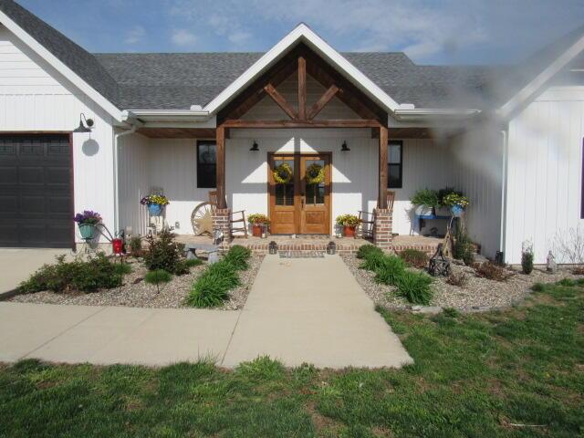 property entrance with covered porch and an attached garage