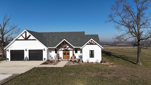 modern inspired farmhouse with a garage, concrete driveway, a front lawn, and french doors