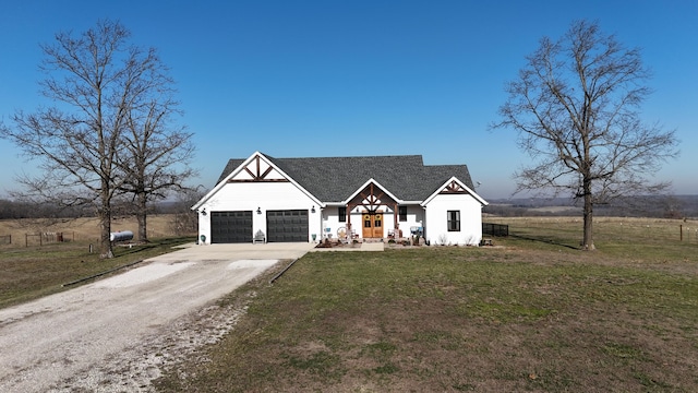 modern inspired farmhouse featuring an attached garage, driveway, and a front lawn