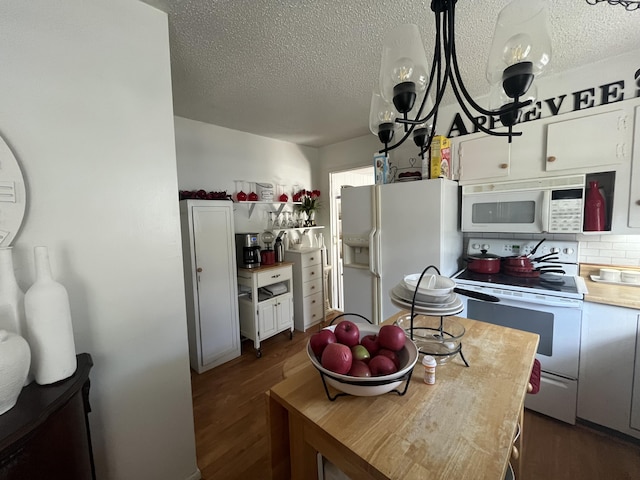 1131 Polk St, Warsaw, MO 65355 - kitchen with dark wood-type flooring, white appliances, a textured ceiling, and backsplash