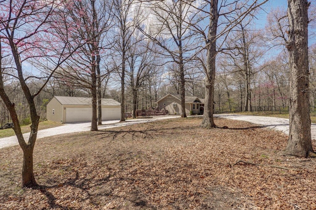 view of yard featuring a garage, driveway, and an outdoor structure