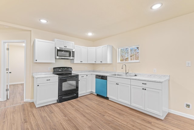 kitchen with black range with electric cooktop, dishwasher, a sink, light wood-style floors, and stainless steel microwave