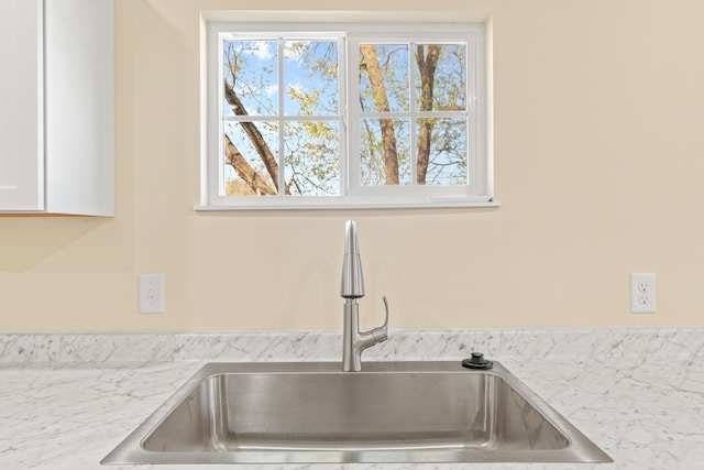 interior details with white cabinets, light countertops, and a sink