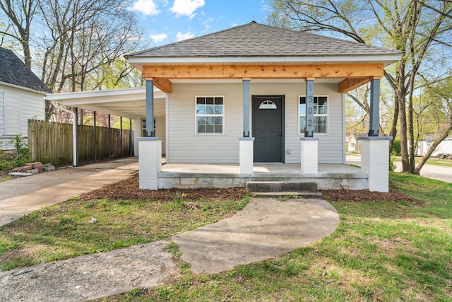 view of front of home featuring driveway, an attached carport, a porch, fence, and a shingled roof