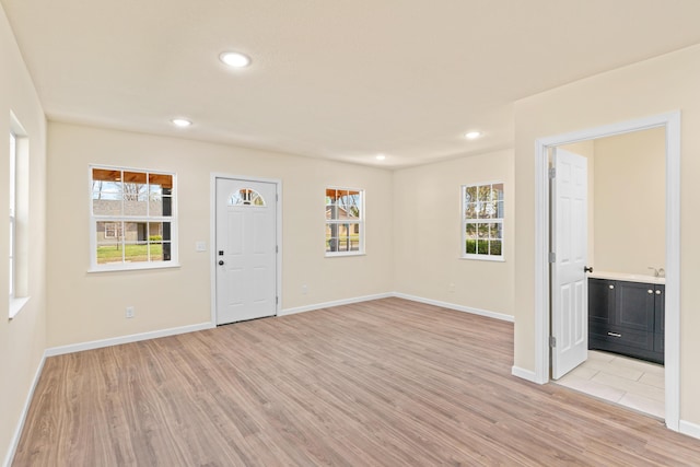 foyer entrance with light wood-style floors, a healthy amount of sunlight, baseboards, and recessed lighting