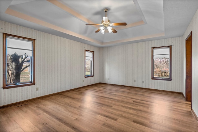 3131 E Southern Hills Blvd, Springfield, MO 65804 - spare room with a tray ceiling, a wealth of natural light, a ceiling fan, and wood-type flooring