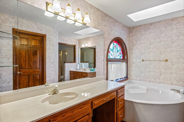 3131 E Southern Hills Blvd, Springfield, MO 65804 - bathroom with vanity, wallpapered walls, toilet, a skylight, and a garden tub