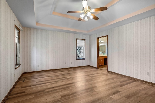 3131 E Southern Hills Blvd, Springfield, MO 65804 - unfurnished room with baseboards, a raised ceiling, wood finished floors, and a ceiling fan