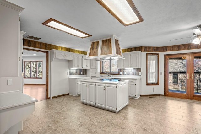 3131 E Southern Hills Blvd, Springfield, MO 65804 - kitchen with baseboards, light countertops, white cabinetry, a kitchen island, and visible vents