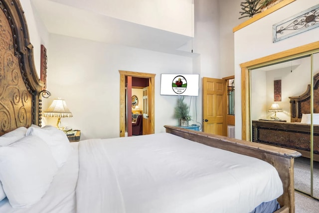 carpeted bedroom featuring a closet and a high ceiling