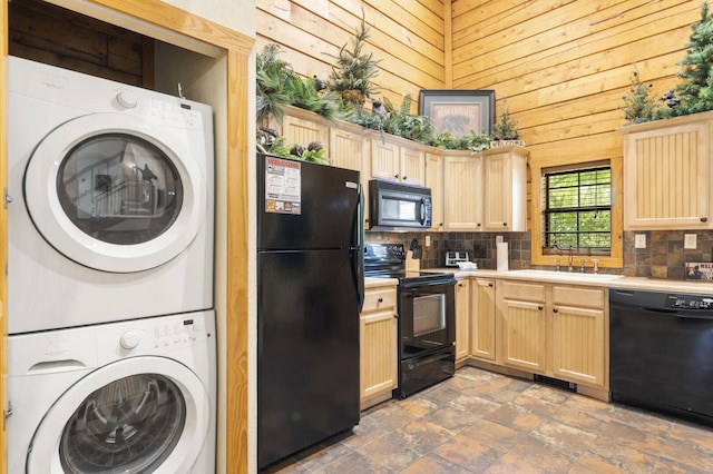 kitchen with stacked washer / dryer, light brown cabinets, backsplash, and black appliances