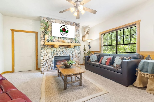 carpeted living room featuring a ceiling fan, wainscoting, and a fireplace